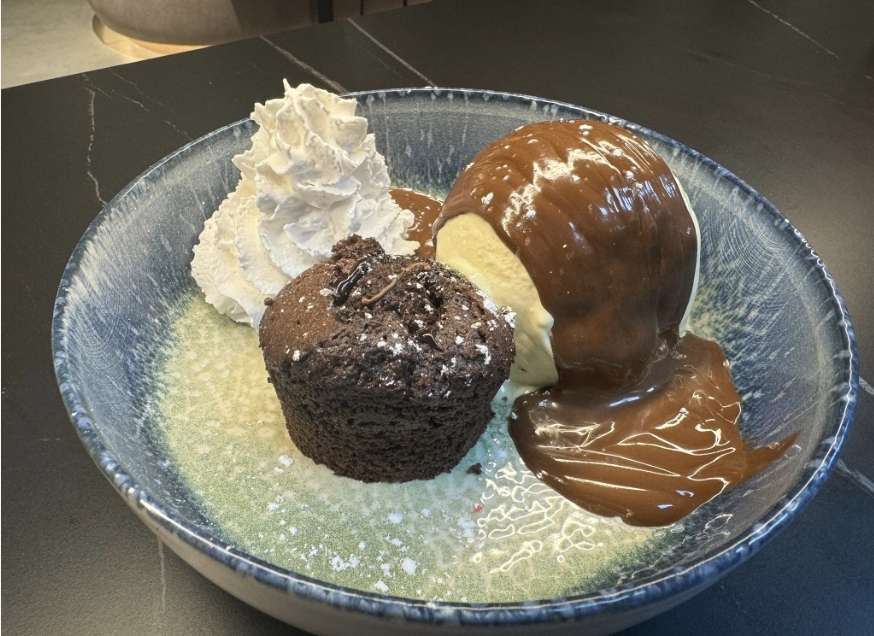 Coulant de chocolate caliente con helado de vainilla nata montada y siropes